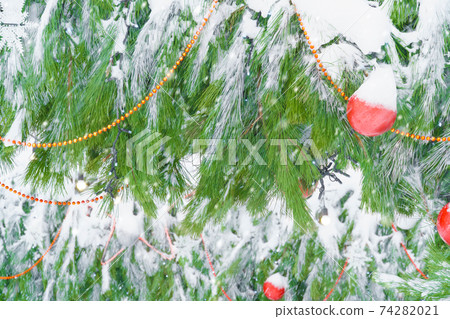 christmas or New Year decorations covered with snow on the street on the Christmas tree close view christmas or New Year decorations covered with snow on the street on the Christmas tree close view 74282021