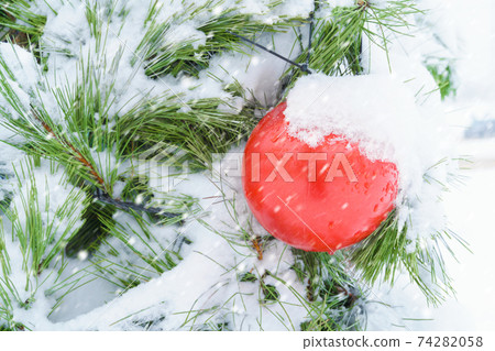 christmas or New Year decorations covered with snow on the street on the Christmas tree close view christmas or New Year decorations covered with snow on the street on the Christmas tree close view 74282058