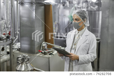 Young Woman Controlling Production at Food Factory Workshop 74282708
