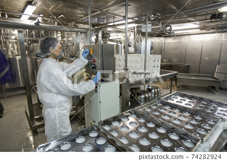 Female Worker Operating Conveyor at Food Factory 74282924