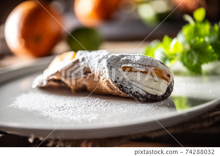 Sicilian Cannoli sweet dessert topped with sugar served on a plate 74288032