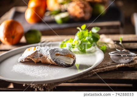 Sicilian Cannoli sweet dessert topped with sugar served on a plate Sicilian Cannoli sweet dessert topped with sugar served on a plate 74288033