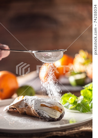 Sicilian Cannoli sweet dessert topped with sugar on a rustic background 74288034