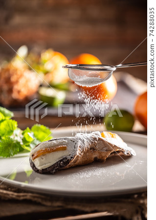 Sicilian Cannoli sweet dessert topped with sugar on a rustic background 74288035