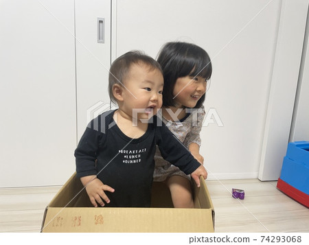 Baby boys and girls playing happily with cardboard Baby boys and girls playing happily with cardboard 74293068