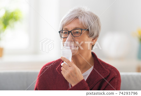 Elderly woman using inhaler for asthma Elderly woman using inhaler for asthma 74293796