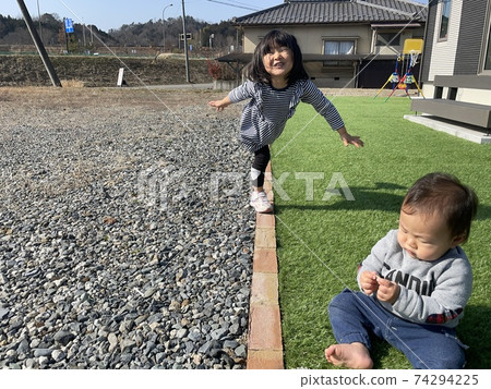 Baby girls and boys playing in the garden 74294225