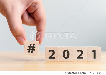 Hashtag of the year 2021, Hand holding wooden block with number 2021 and icon hashtag 74294340