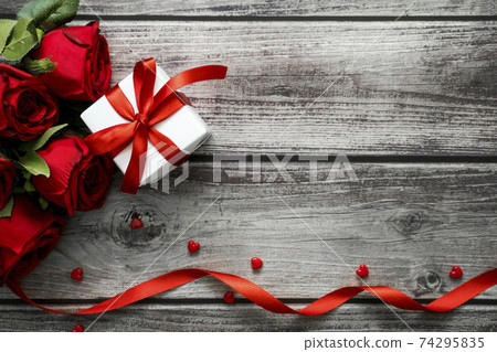 Love and Valentine background with copyspace for text with top view red roses, presents and heart on old wooden table Love and Valentine background with copyspace for text with top view red roses, presents and heart on old wooden table 74295835