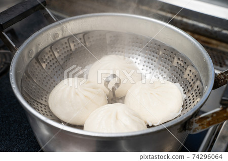 Steam the meat buns and steamed buns in a pan. Steam the meat buns and steamed buns in a pan. 74296064