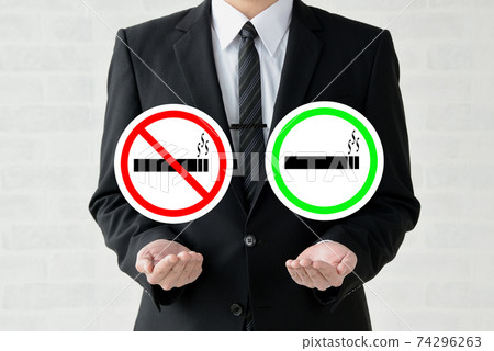 A businessman holding a smoking cessation mark and a smoking mark A businessman holding a smoking cessation mark and a smoking mark 74296263