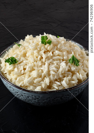 Rice in a bowl, cooked, garnished with fresh parsley, close-up Rice in a bowl, cooked, garnished with fresh parsley, close-up 74296906