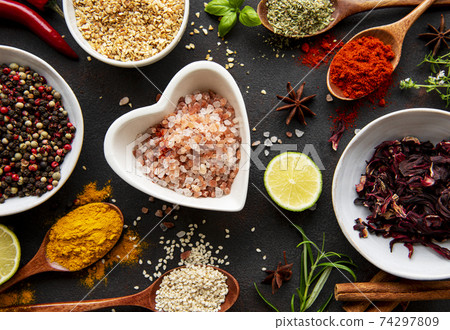 Colorful and aromatic herbs and spices on a dark background 74297809