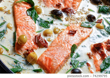 Tuscan salmon with cream sauce on a black dish 74299795