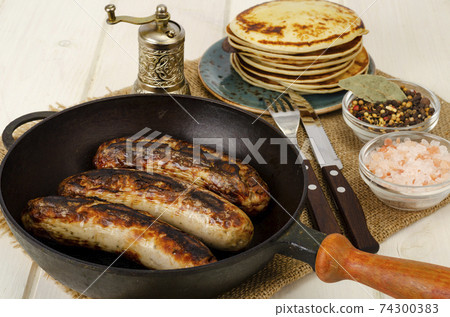 Grilled sausages, pancakes on white wooden table. Grilled sausages, pancakes on white wooden table. 74300383