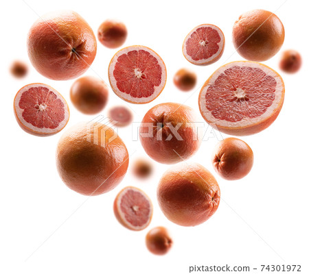 Whole and cut grapefruits in the shape of a heart on a white background 74301972