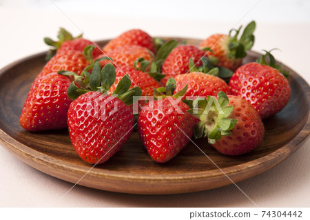 Strawberries on a wooden bowl Strawberries on a wooden bowl 74304442
