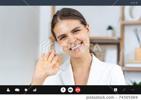Caucasian woman in formal business suit waving bye bye while making video call Caucasian woman in formal business suit waving bye bye while making video call 74305069