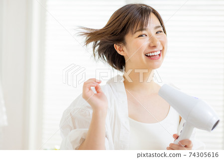 做吹風機的年輕女子 74305616