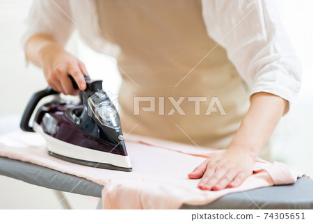 Woman ironing 74305651