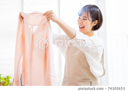 一位年輕的女士洗衣服 74305653