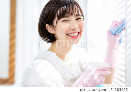 Young woman cleaning the house Young woman cleaning the house 74305665
