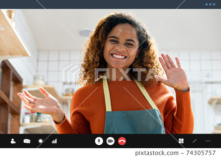 Pretty African American woman smiling and waving hands making video call Pretty African American woman smiling and waving hands making video call 74305757