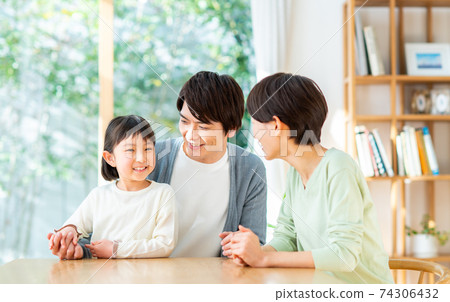 Young family relaxing in the dining room Young family relaxing in the dining room 74306432