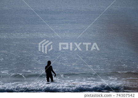 Surfer entering the sea Surfer entering the sea 74307542