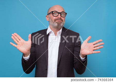 Confused man standing with raised arms and looking at camera having no answer. Confused man standing with raised arms and looking at camera having no answer. 74308164