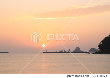 Sunrise while drawing a line of light on the sea of calm 74310071