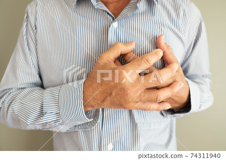 Heart attack problems. Elderly man suffering from severe chest pain. Warning signs of unstable angina or myocardrial infarction disease. Health care and cardiological concept. Close up. Heart attack problems. Elderly man suffering from severe chest pain. Warning signs of unstable angina or myocardrial infarction disease. Health care and cardiological concept. Close up. 74311940