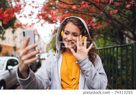 Young woman with smartphone outdoors on street, video for social media concept. 74313293