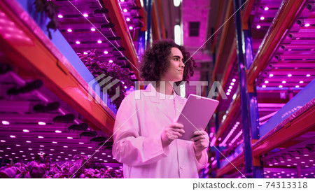 Worker with tablet on aquaponic farm, sustainable business and artificial lighting. Worker with tablet on aquaponic farm, sustainable business and artificial lighting. 74313318