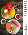 Ingredients for fish soup, salmon, tilapia, red pepper, onion, carrot, lemon, green and black olives. Top view, wooden rustic table 74313371