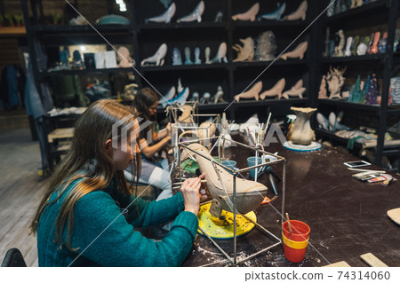 People carefully work on clay whales in workshop People carefully work on clay whales in workshop 74314060