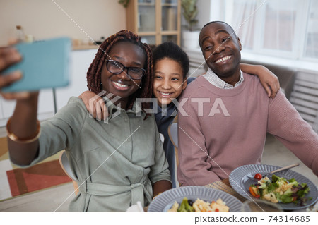 Modern African American Family Taking SElfie at Dinner Table 74314685
