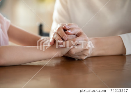 Close up of caring mom hold little daughter hands 74315227
