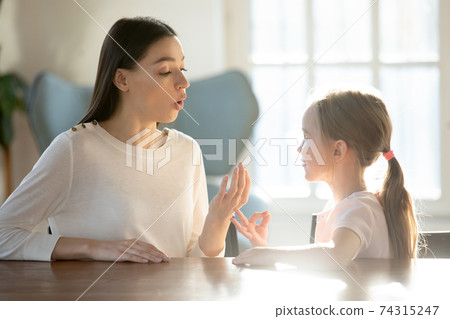 Caring young mom learn pronouncing sounds with daughter 74315247
