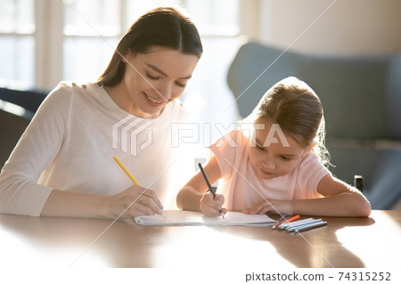 Happy young mom and little daughter draw in album Happy young mom and little daughter draw in album 74315252