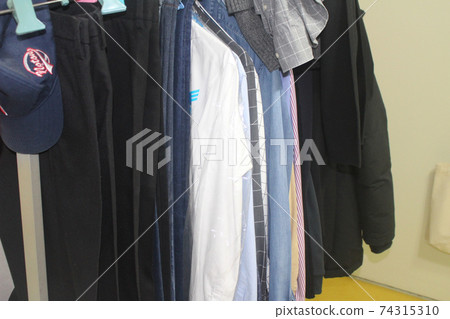 Unorganized clothes hanging on hangers Unorganized clothes hanging on hangers 74315310