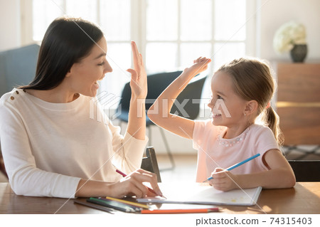 Happy mom and cute small daughter give high five 74315403