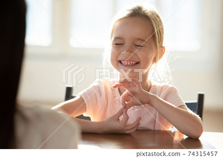 Happy small girl child have fun talking with mom 74315457
