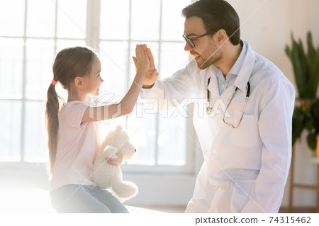 Happy male doctor have fun play with small girl child 74315462