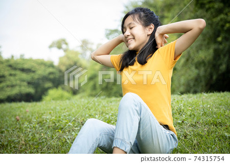 Happy asian child girl resting feel comfortable at park,female teenager with hands behind her head and closed eyes,healthy woman enjoy breathing fresh air,relaxing in green nature after studying Happy asian child girl resting feel comfortable at park,female teenager with hands behind her head and closed eyes,healthy woman enjoy breathing fresh air,relaxing in green nature after studying 74315754