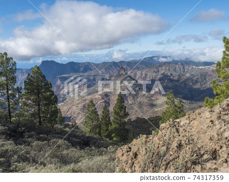 Amazing view from Roque Nublo plateau on central volcanic mountains with Caldera and Barranco de Tejeda and Roque Bentayg rock. Gran Canaria, Canary Islands, Spain. 74317359