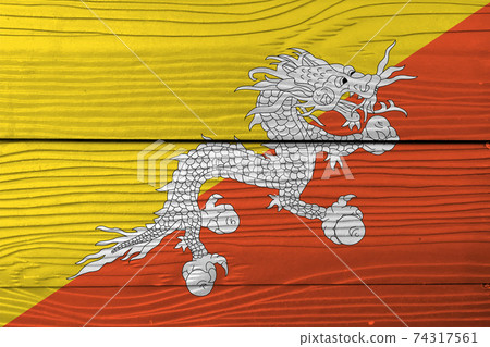 Flag of Bhutan on wooden wall background. Grunge Bhutan flag texture Flag of Bhutan on wooden wall background. Grunge Bhutan flag texture 74317561