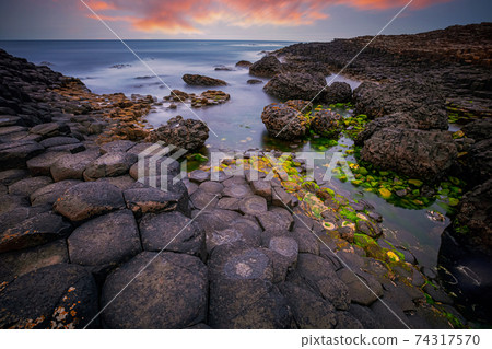 sunset over rocks formation Giants Causeway, County Antrim, Northern Ireland, UK 74317570