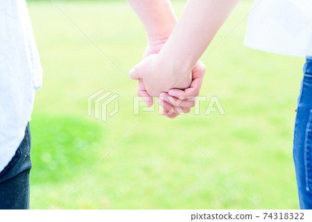 A couple of men and women holding hands on a beautiful lawn, good friends, peace 74318322