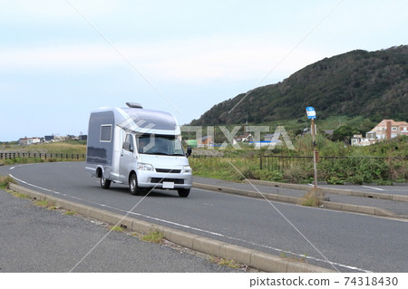 Camper running in a town by the sea Camper running in a town by the sea 74318430